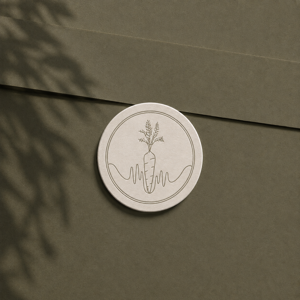 Close-up mockup of a textured olive-green envelope featuring a cream embossed circular seal with the Landis Nutrition carrot and heartbeat-inspired submark, photographed with soft natural shadows for an earthy, refined wellness aesthetic.